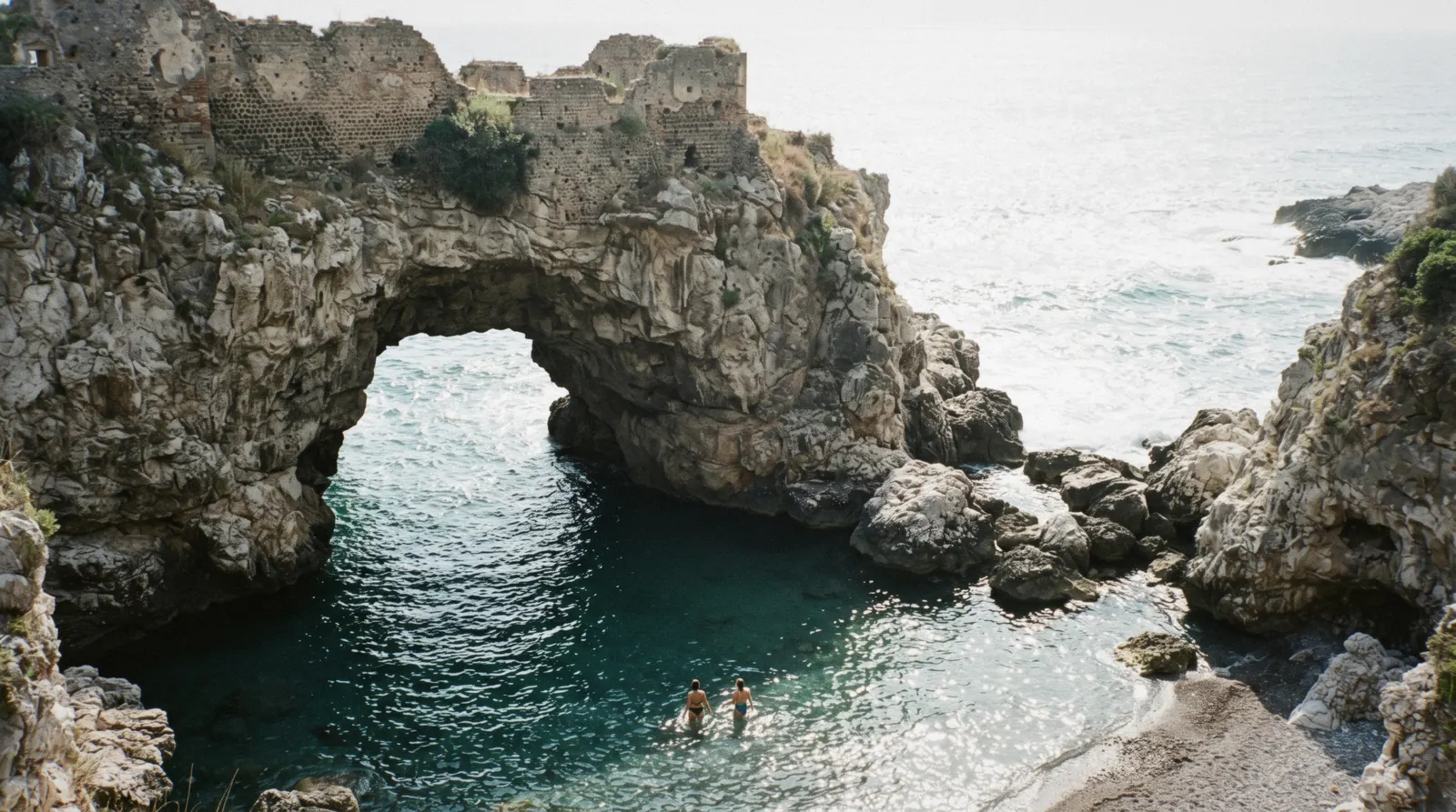 The natural pool of Bagni Regina Giovanna at Capo di Sorrento, with the rock arch opening to the sea and the Roman ruins on the cliff