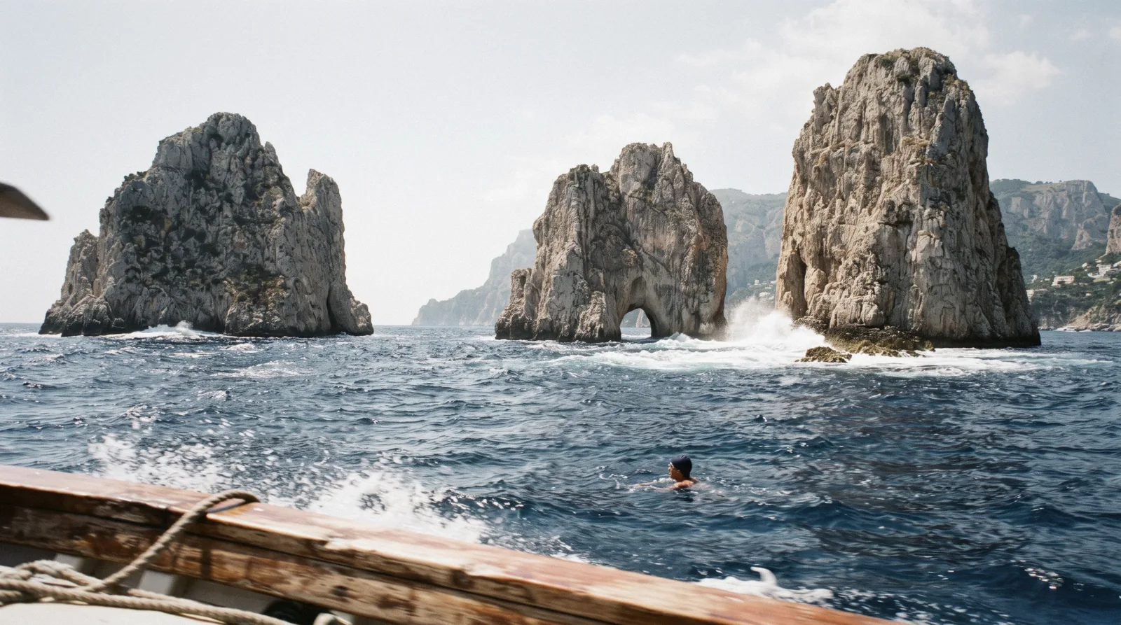 Faraglioni rocks and blue water seen from a boat off Capri